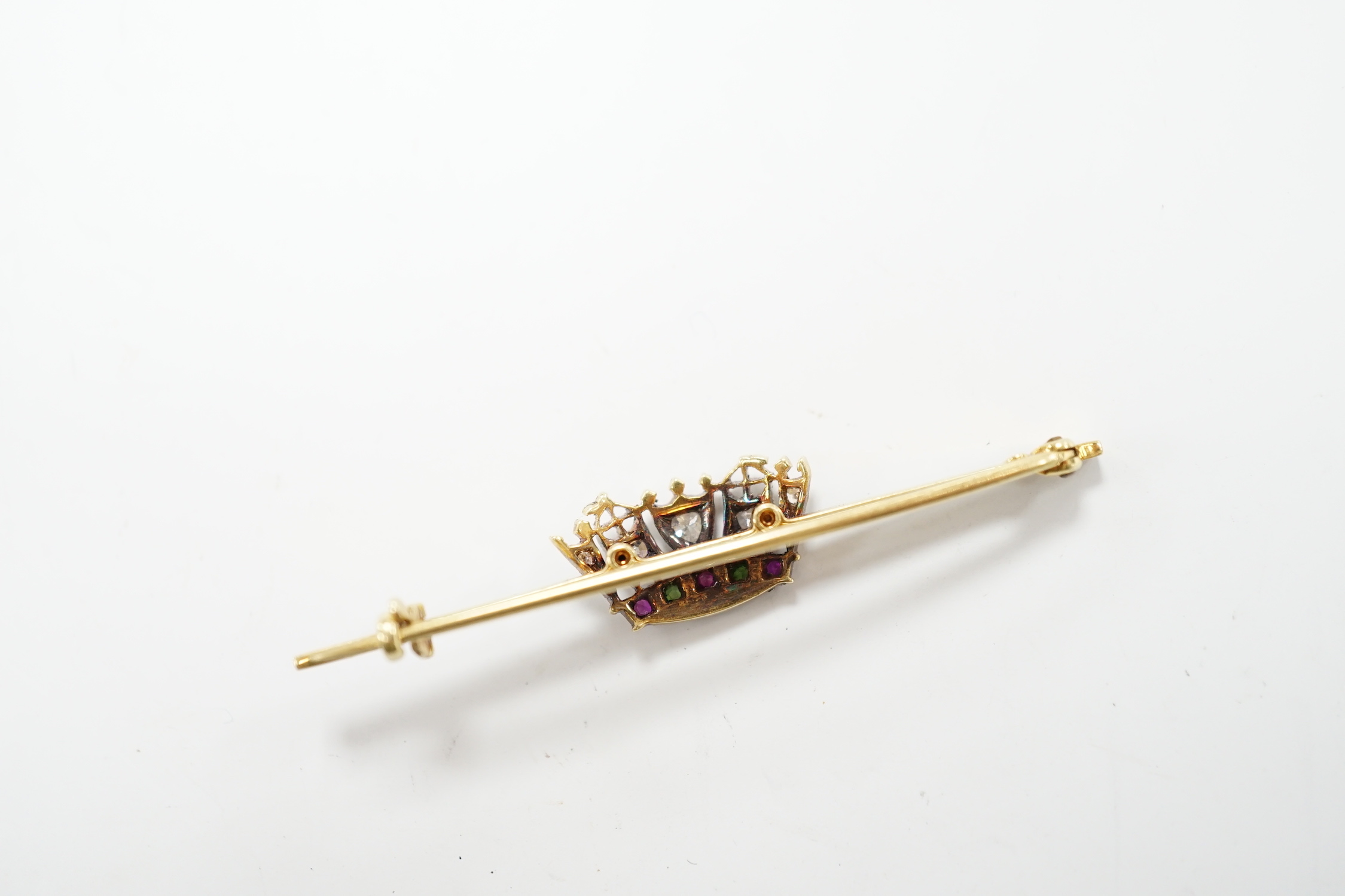 An early 20th century, 15ct and plat. ruby, green garnet and diamond set coronet bar brooch, 50mm, gross weight 3.4 grams.